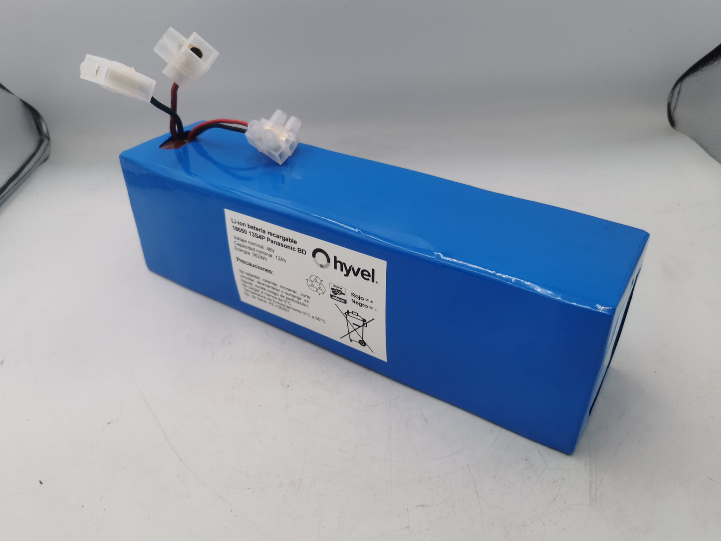 Vista frontal de la Batería 48v 10ah mostrando el plástico azul protector y etiqueta blanca con especificaciones y cables conectores.