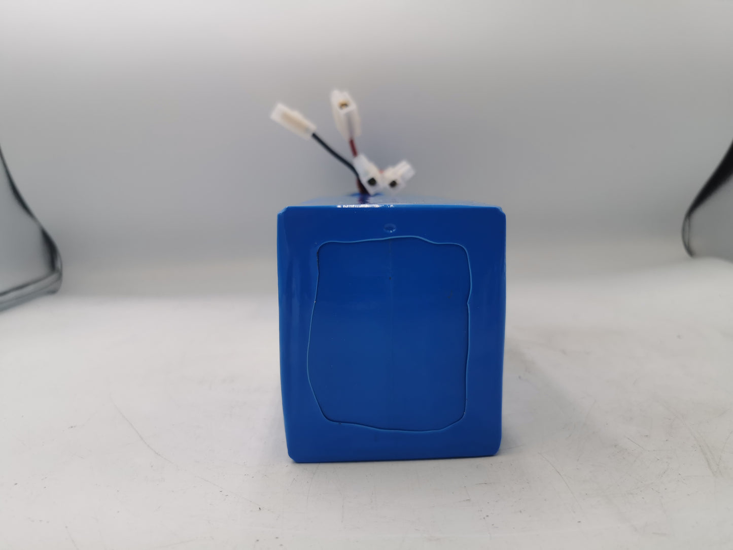 Parte inferior de la Batería 48v 10ah con plástico azul que la recubre en un fondo blanco.