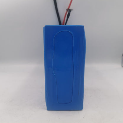 Ángulo alternativo donde se aprecian la batería, el cargador y etiquetas técnicas con diseño en verde.